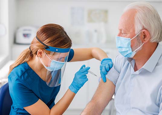Nurse giving man flu vaccine